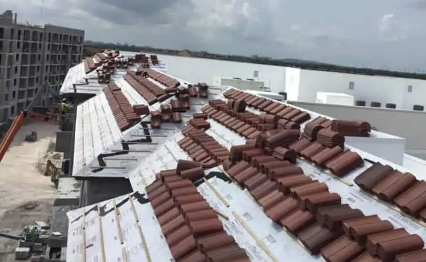 Red roofing tiles installed on white residential roof at 6600 Main Street.