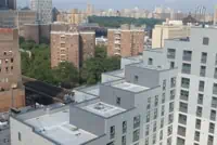 Aerial view of multi-story buildings with mixed exteriors and New York skyline.