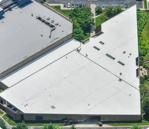 Aerial view of commercial building with white triangular roof and team