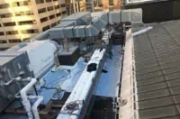 HVAC units on Boise commercial flat roof amidst tall buildings