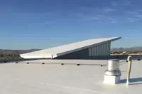 Flat commercial roof with angled structure and Fresno skyline