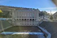 Hydroelectric dam with arched windows and bridge in Sacramento under clear sky.
