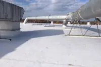 Flat white roof with HVAC units, Indianapolis sky