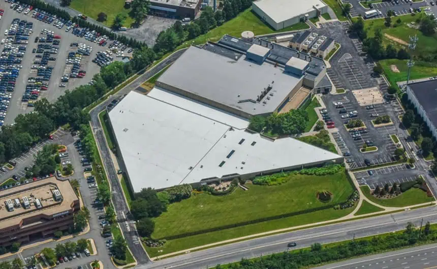 Aerial view of industrial complex with flat roofs, green spaces.