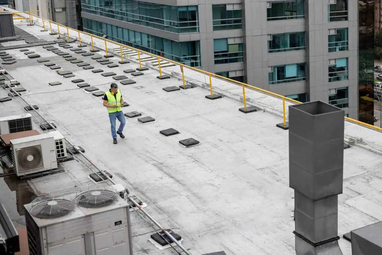 Professional conducts commercial roofing system maintenance inspection
