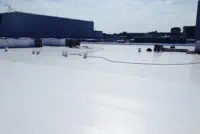 Flat White Reflective Roof with Coiled Hoses and Storage Containers