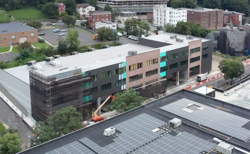 Aerial view of a construction site with vibrant green and blue panels roofing.