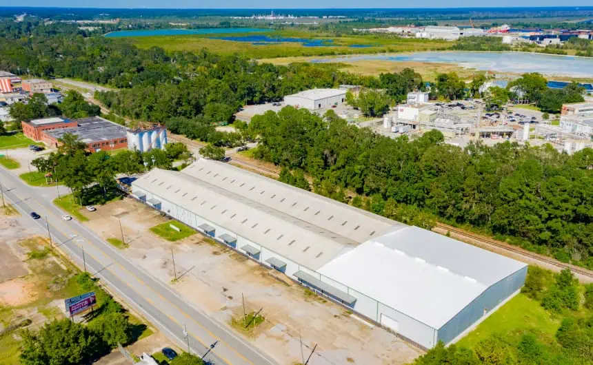 Aerial view of warehouse with commercial flat roof amidst industrial area
