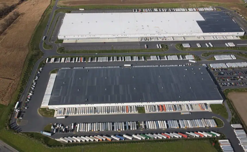 Aerial view of Nestle warehouses with trucks showcases flat roof system