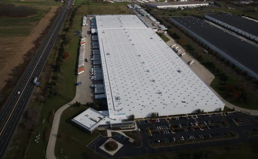 Aerial view of Nestle warehouse with TPO roof, loading docks, and trucks.