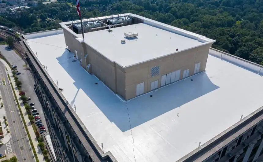 Aerial view of flat commercial roof with HVAC units, flag, and trees in Resurgens Plaza.