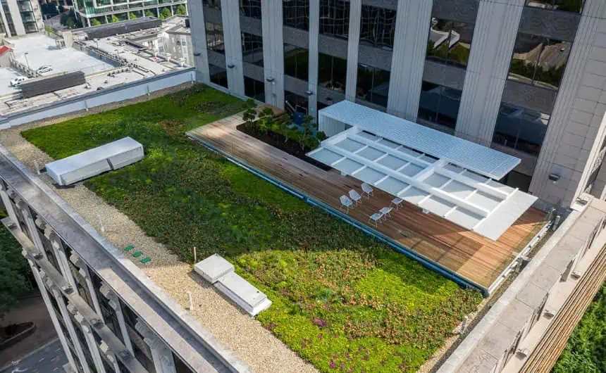 Aerial view: Green rooftop garden on tall commercial building, wooden decking, Resurgens Plaza background.