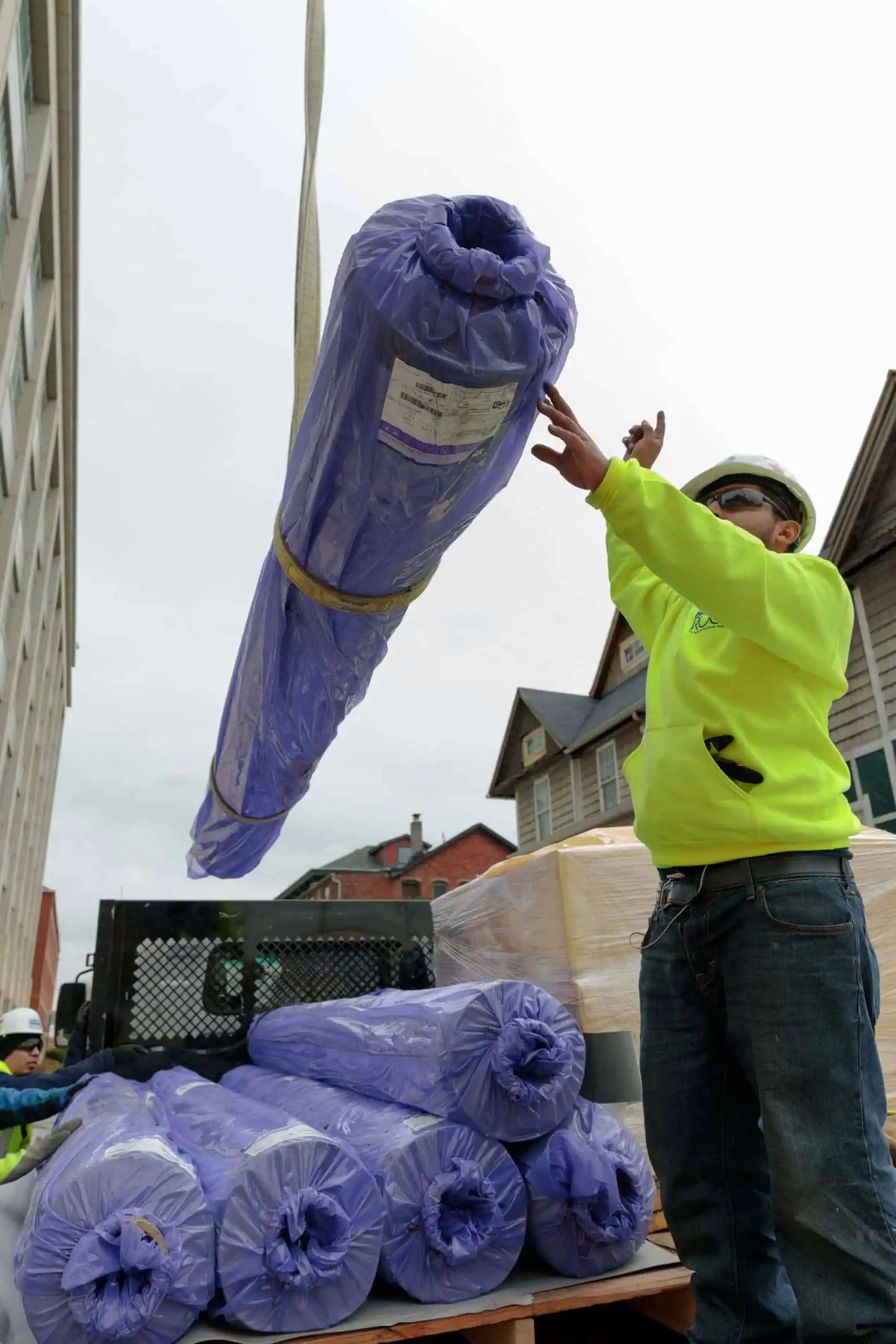 Worker Directs Placement of TPO Roll for Commercial Roofing Project
