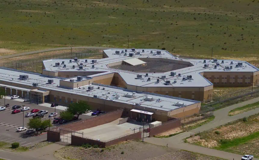 Aerial view of Santa Fe Jail, cross-shaped facility, with parking lot.