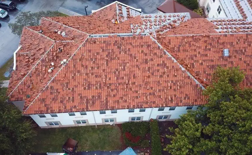 Bird's-eye view: Large building with a reddish-brown tile roof under repair.