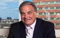 Confident businessman in suit with cityscape, highlighting premium commercial roofing services.