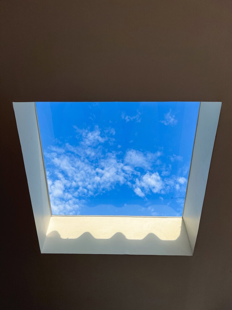 Blue sky through a square skylight designed for daylighting