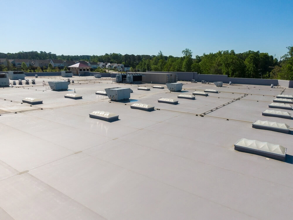 A white TPO roof with multiple skylights on a commercial building.